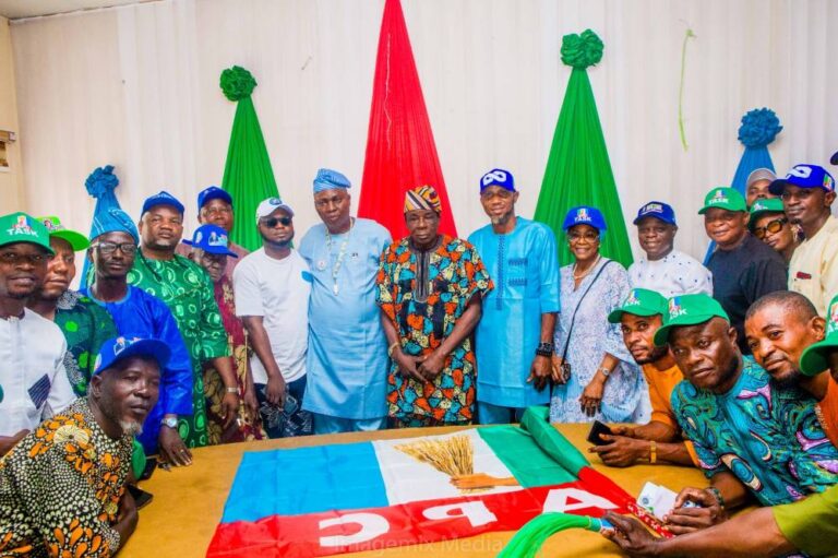 Group of people posing together with an APC political flag.