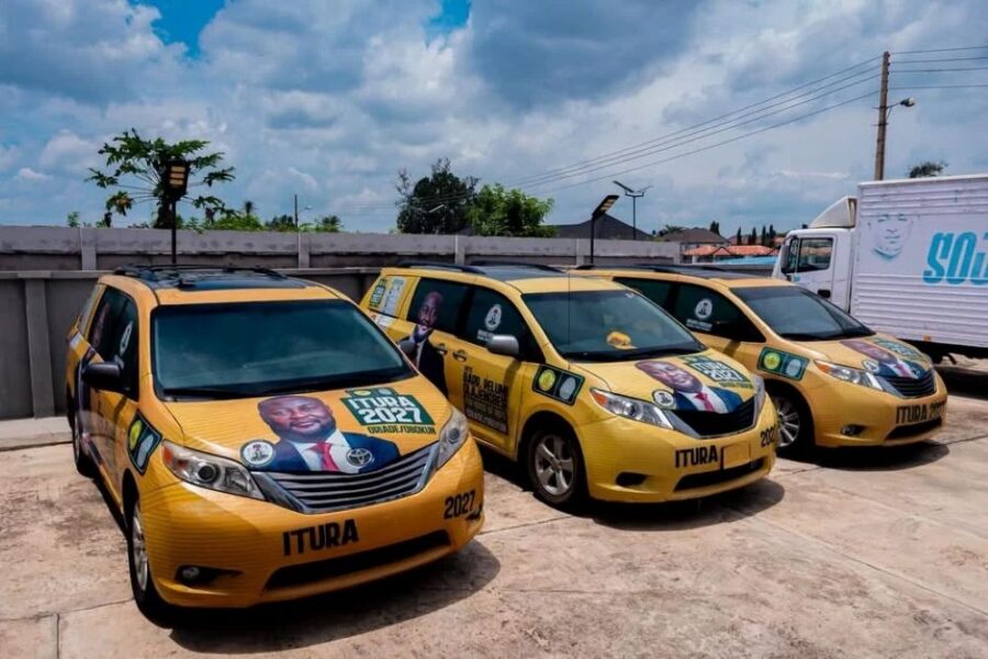 Three yellow Toyota minivans branded for ITURA 2027 political campaign.