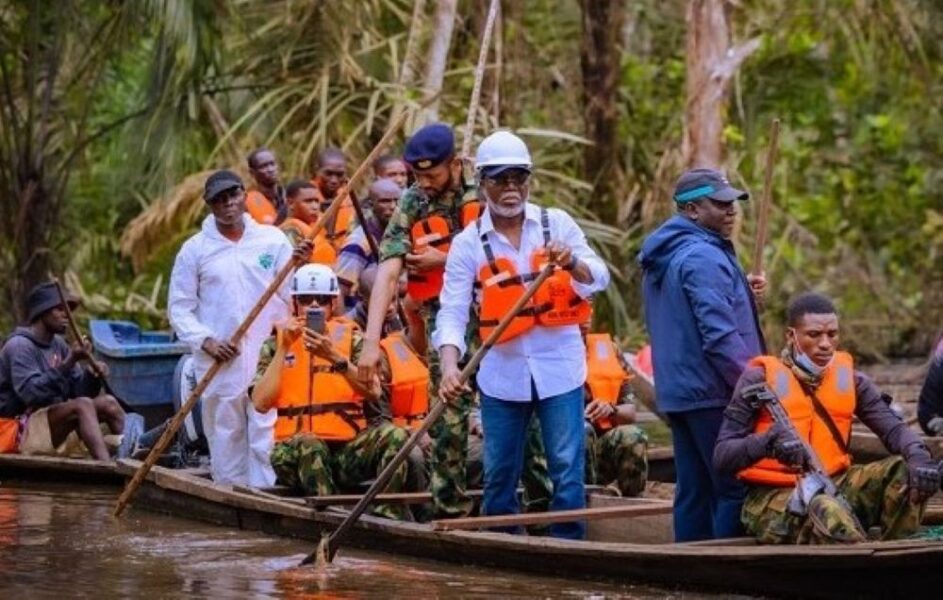 People in life jackets navigating a boat through dense forest.