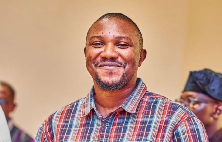 Portrait of a smiling man wearing a plaid shirt.