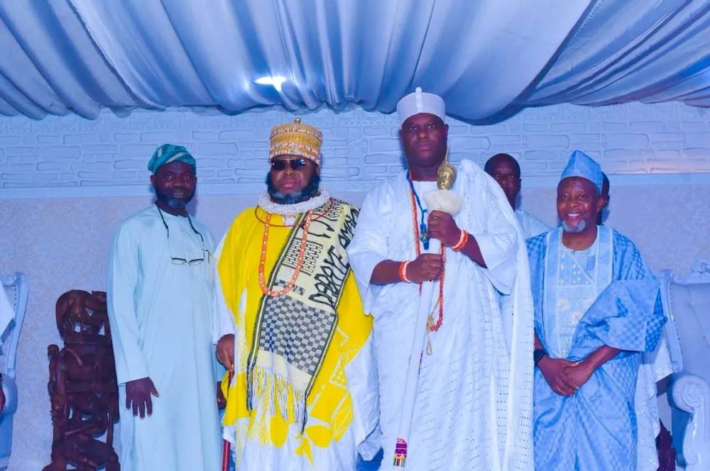 Nigerian traditional rulers in ceremonial attire standing together.